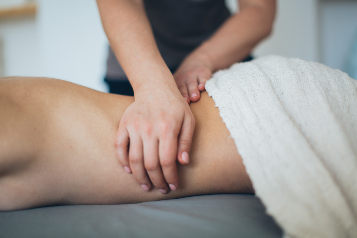 Person Lying in Bed Getting Massage